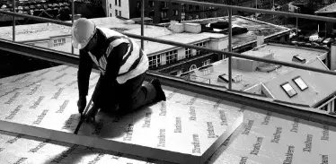 Building professional installing xtratherm insulation boards on roof