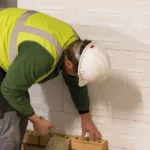 Unilin Insulation image of consruction worker building a wall around cavity therm insulation board