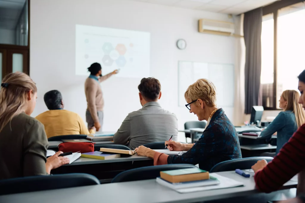 Smiling mature woman takes notes during education training class.